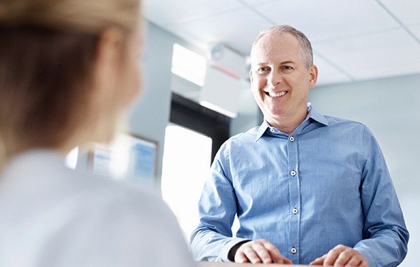 Man checking in at dental reception desk