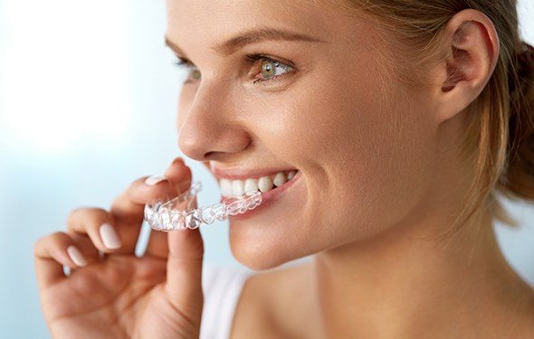 Woman placing an Invisalign tray