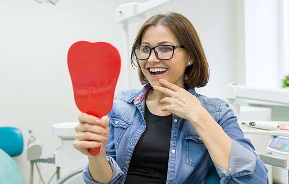 Woman looking at smile in mirror