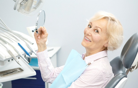 A female patient sitting and smiling in the dentist chair