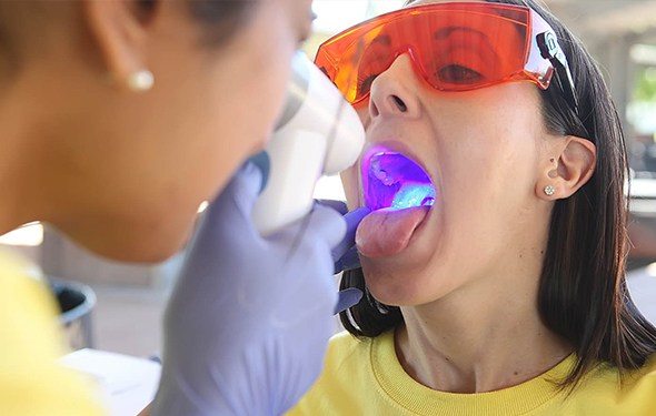 Woman receiving oral cancer screening