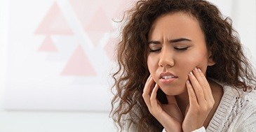 Woman holding jaw in pain