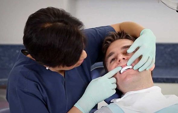Dentist checking fit of sleep apnea appliance